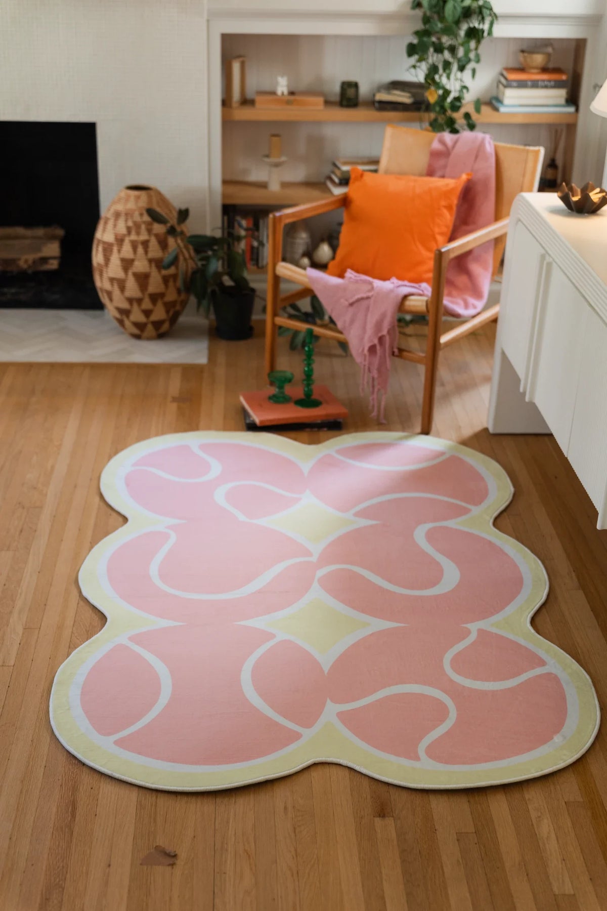 Long view of the pink tennis rug leading toward a wood chair, with curved white lines across the surface