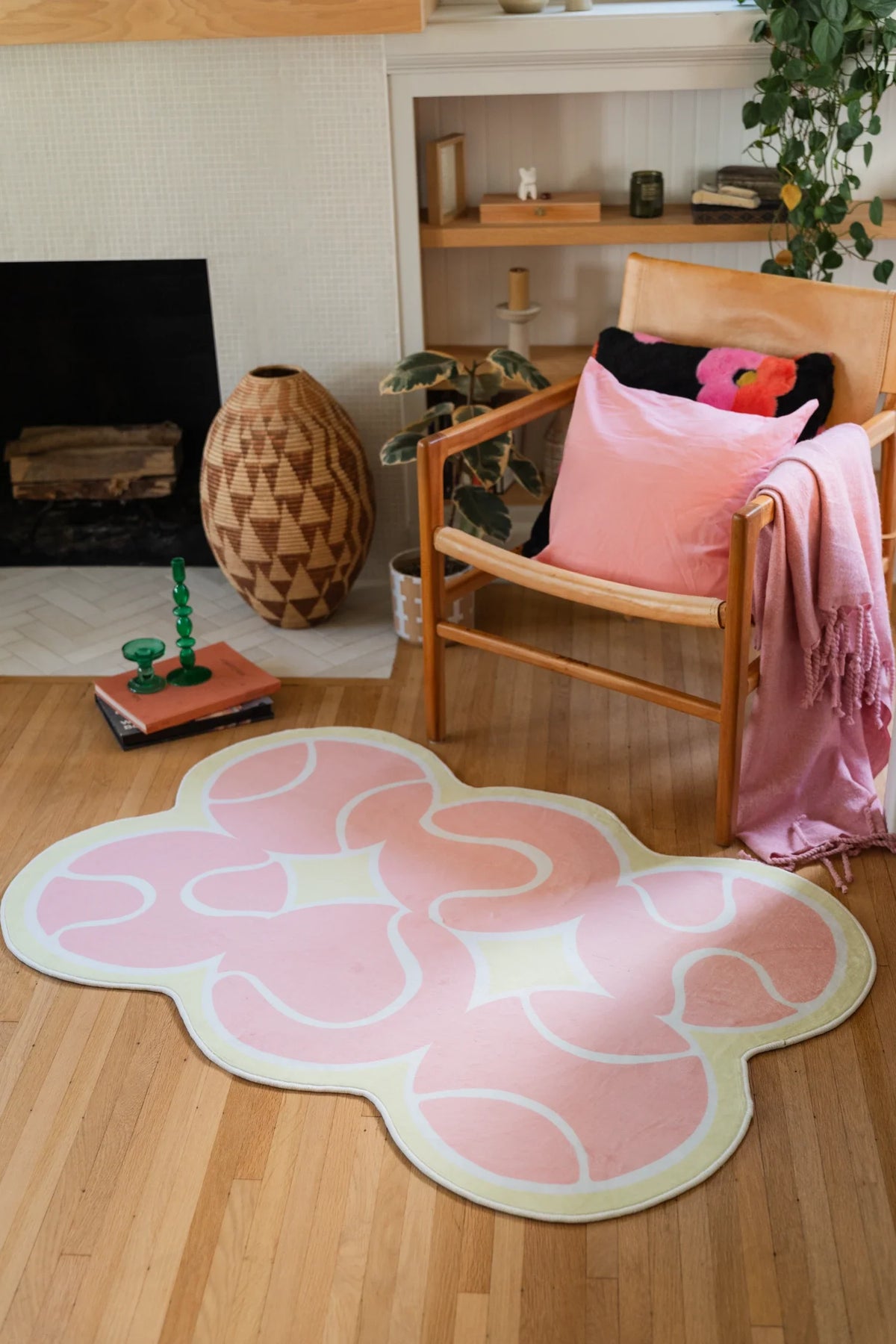 Pink Irregular Tennis Area Rug in a reading corner with a wood chair, fireplace, and woven basket