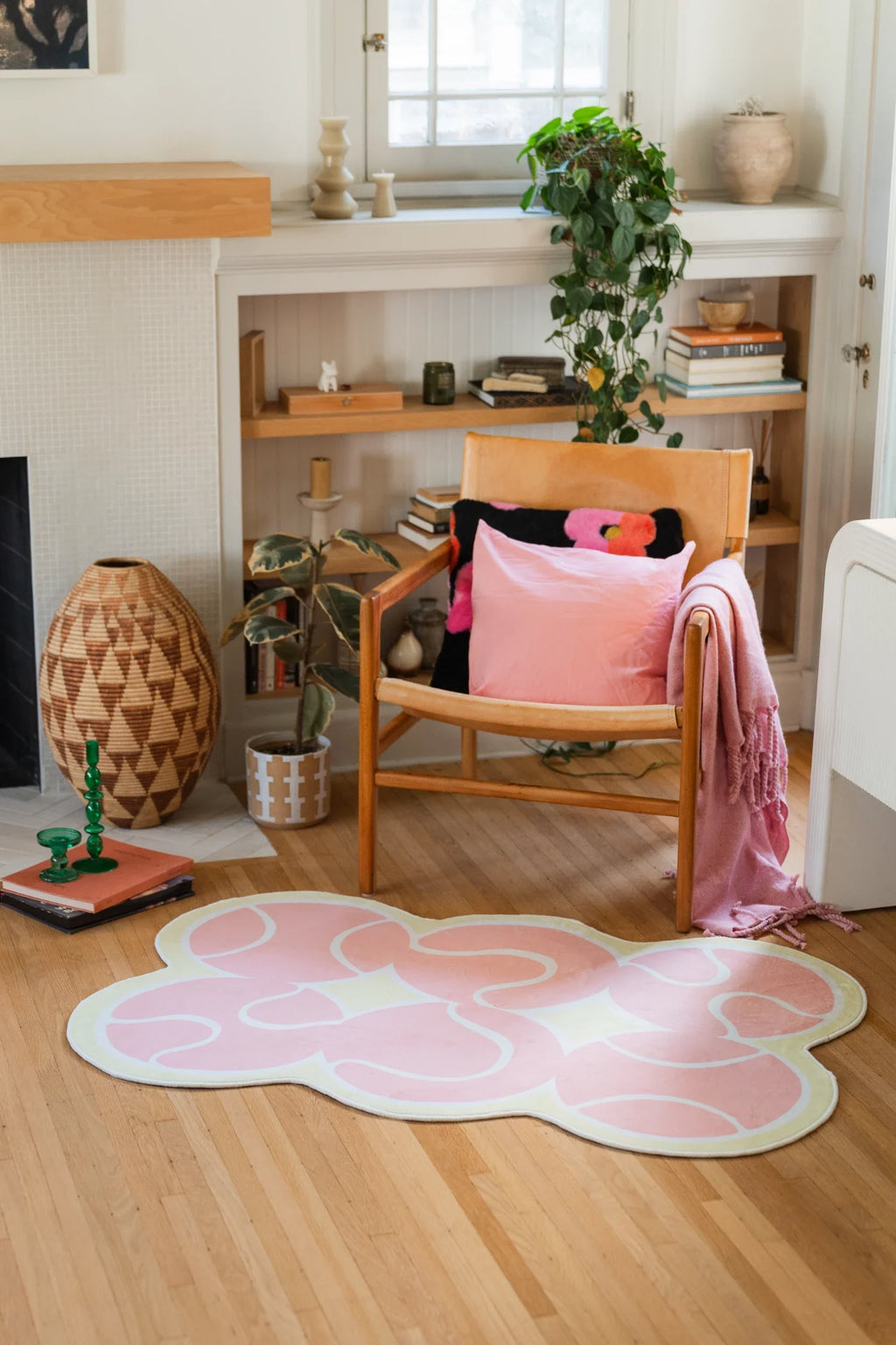 Pink tennis rug styled near shelving and a wood chair, with soft white court lines on a light wood floor