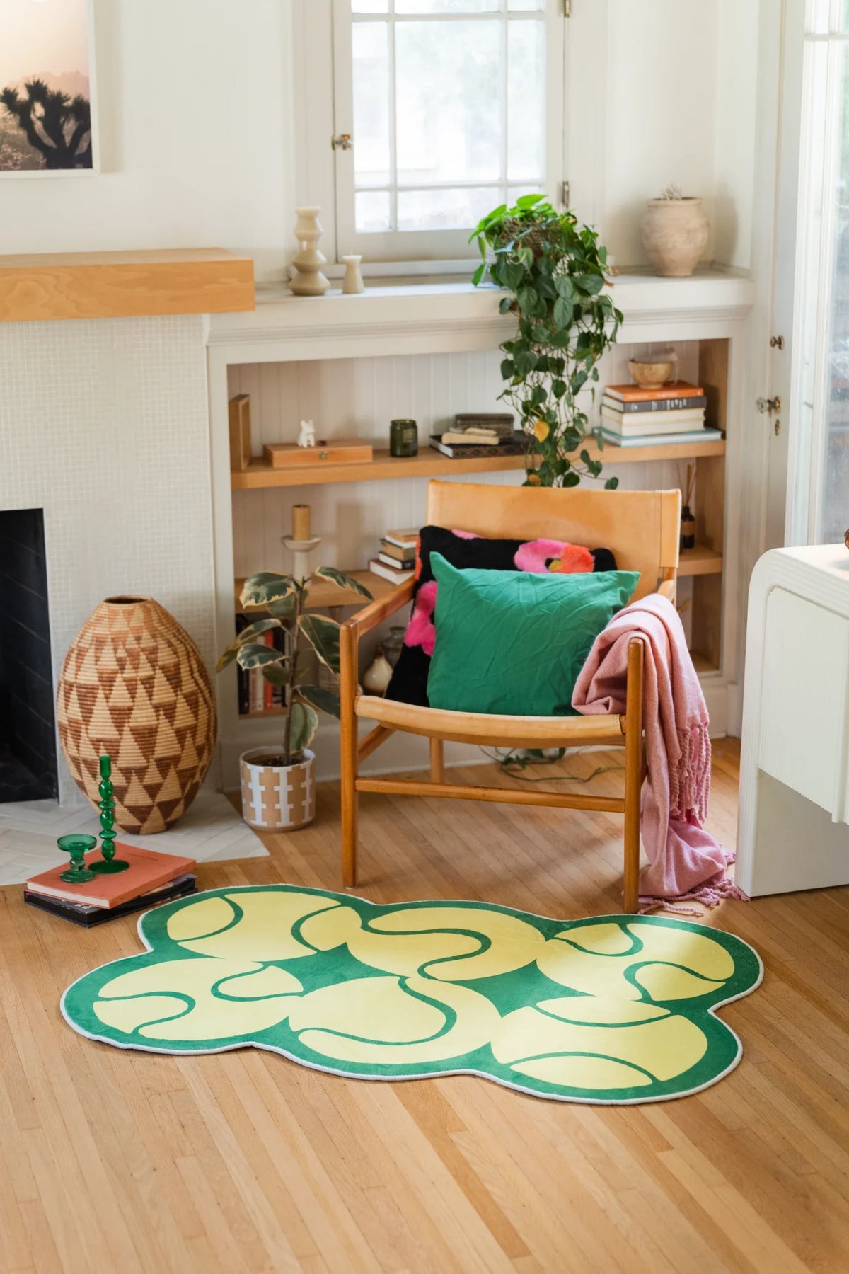 Yellow Irregular Tennis Area Rug by Zoe Wodarz in a cozy corner with a wood chair, books, and light wood floor