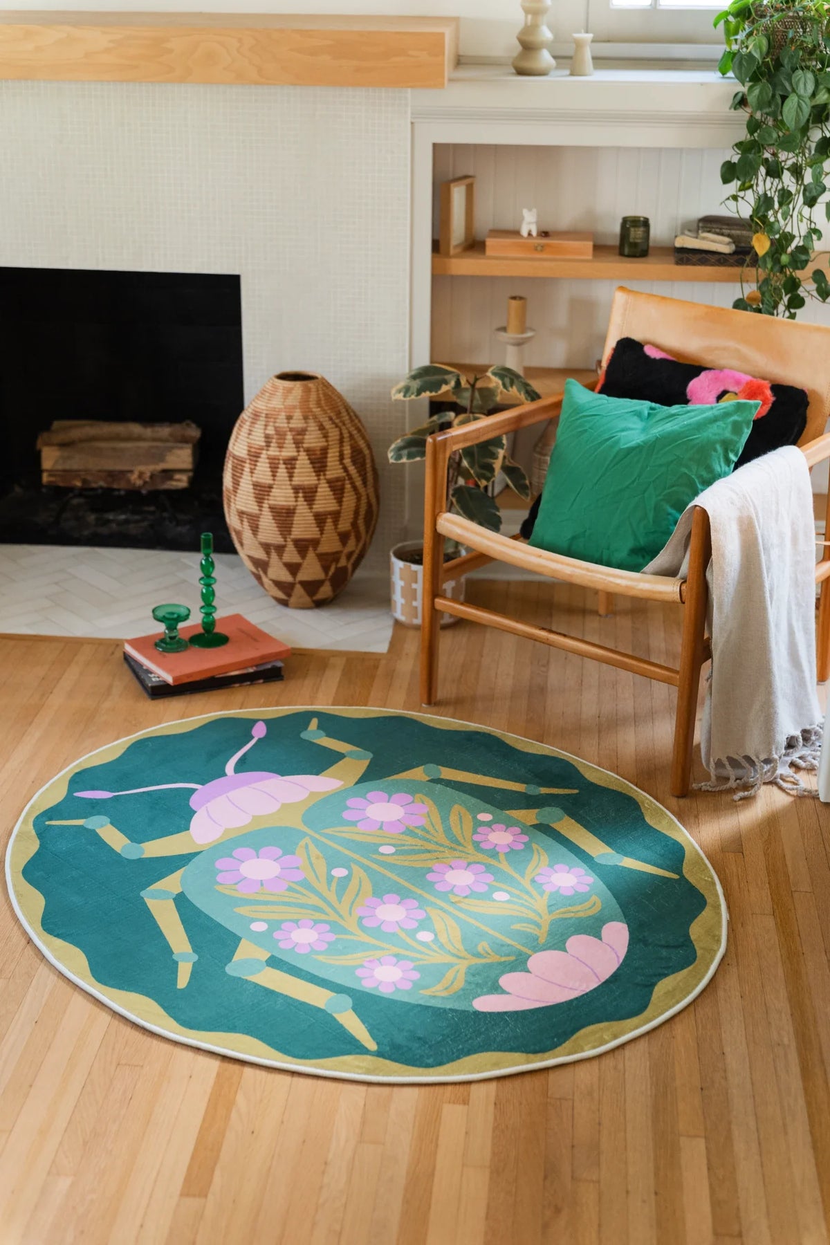Modern round area rug beside the fireplace and chair, combining a beetle like layout with soft pink floral motifs