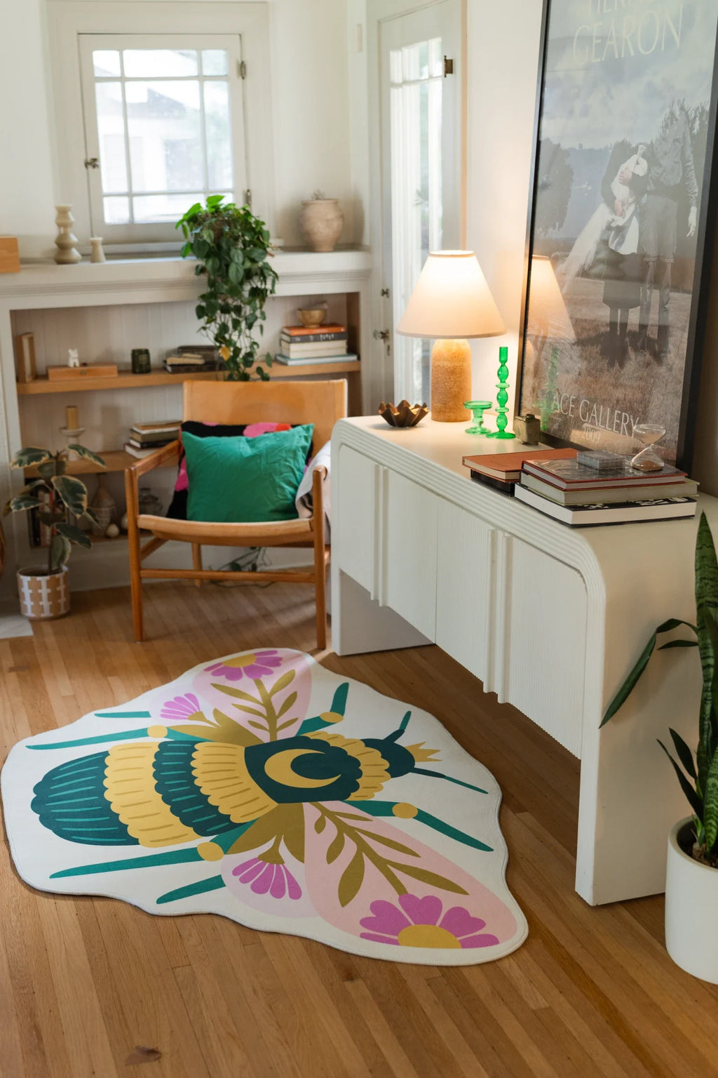 Queen bee shaped area rug in a creative corner with a white media console, lamp, and framed art
