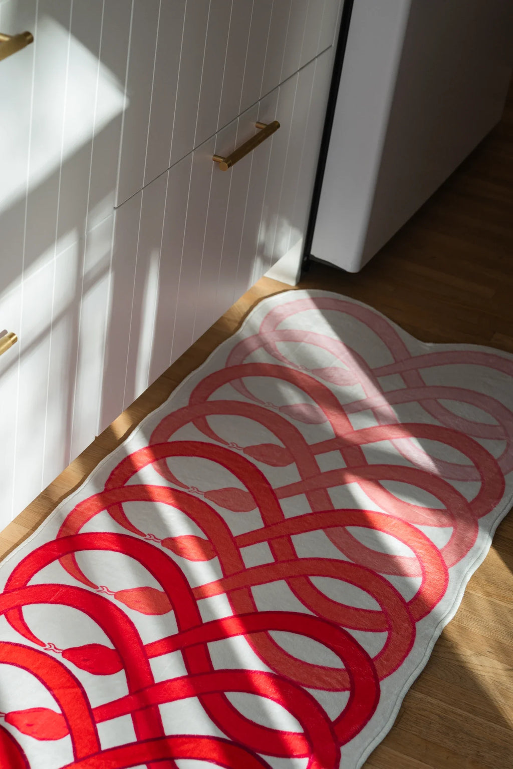 Close up of the loop snake runner with sunlight across the surface, highlighting the layered red rhythm of the pattern