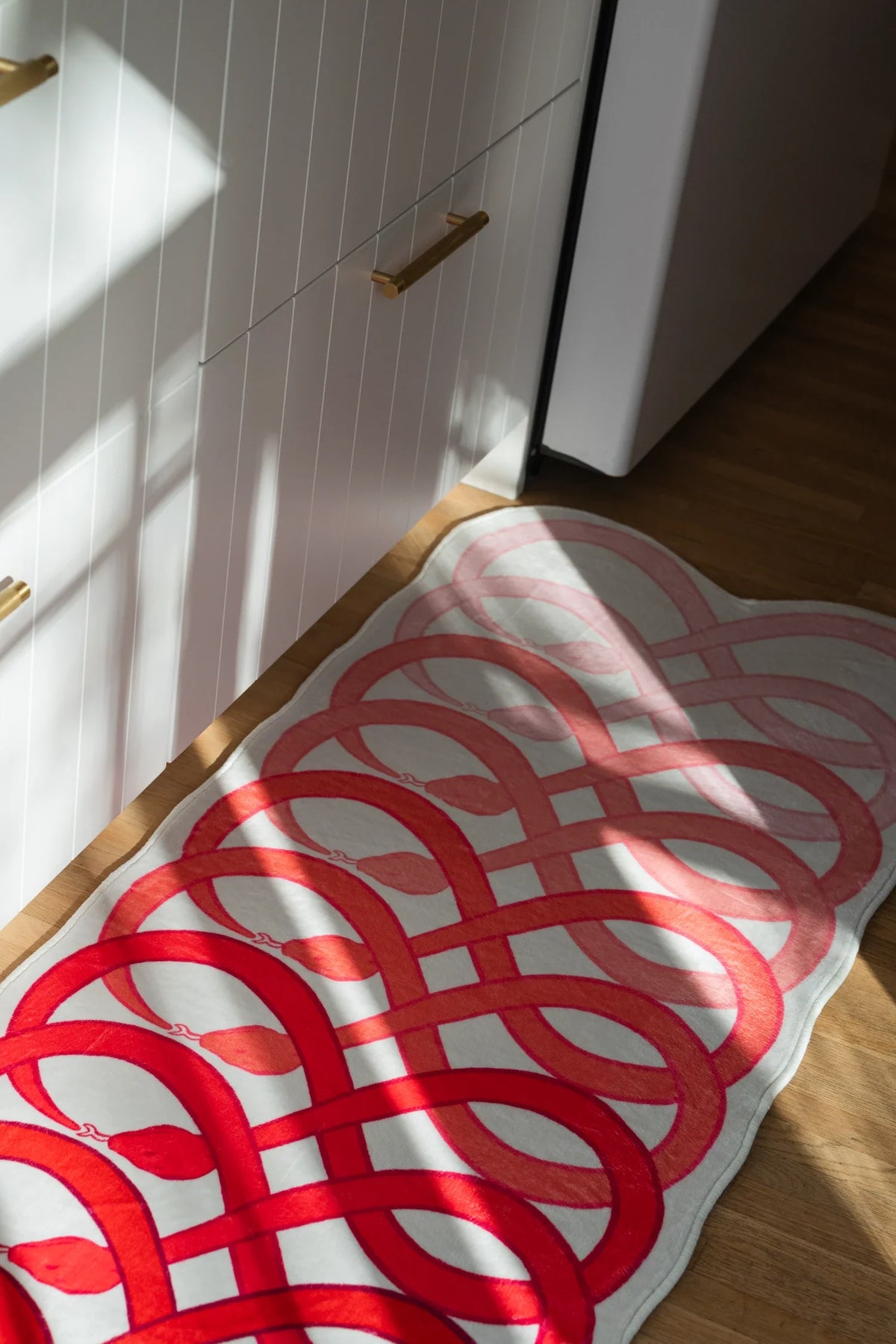 Close up of the loop snake runner with sunlight across the surface, highlighting the layered red rhythm of the pattern