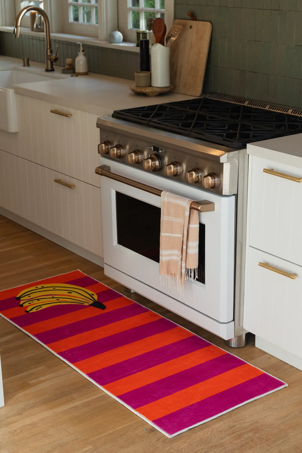 Colorful banana fruit runner rug in a modern kitchen with white cabinetry and a stainless range