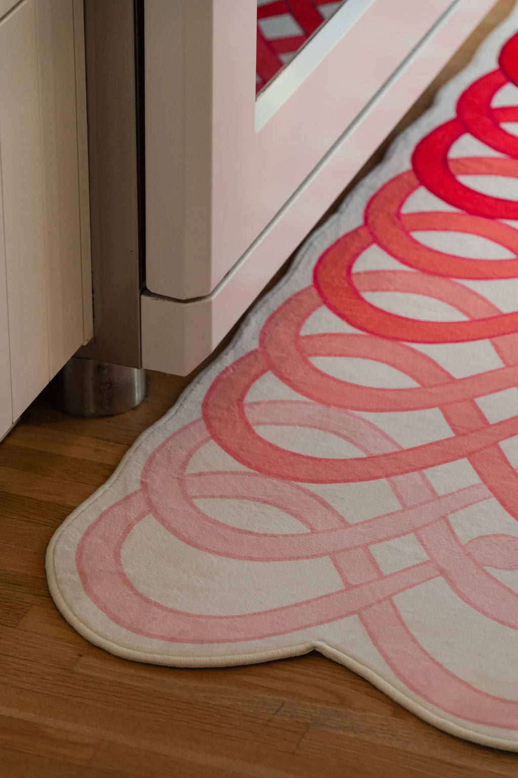 Partial crop of the runner near the oven, focused on the rounded end and repeated coral red loop motif