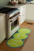 Green Irregular Tennis Runner Rug by Zoe Wodarz beside a white kitchen oven on a light wood floor