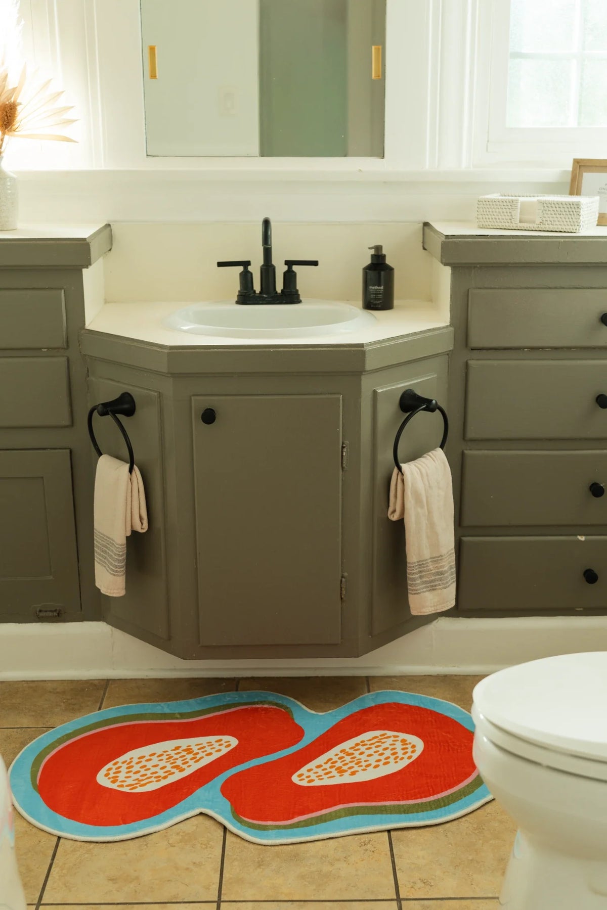 Papaya Orange Irregular Fruit Rug in a bathroom beside a sink vanity and toilet on a tiled floor