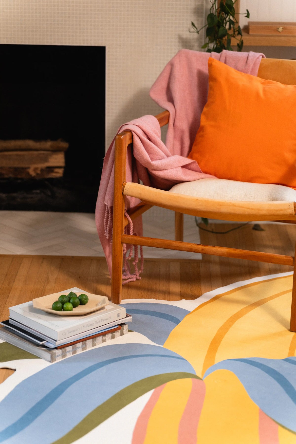 Blue banana peel and yellow fruit section beside a wooden chair, stacked books, and a plate of green fruit.