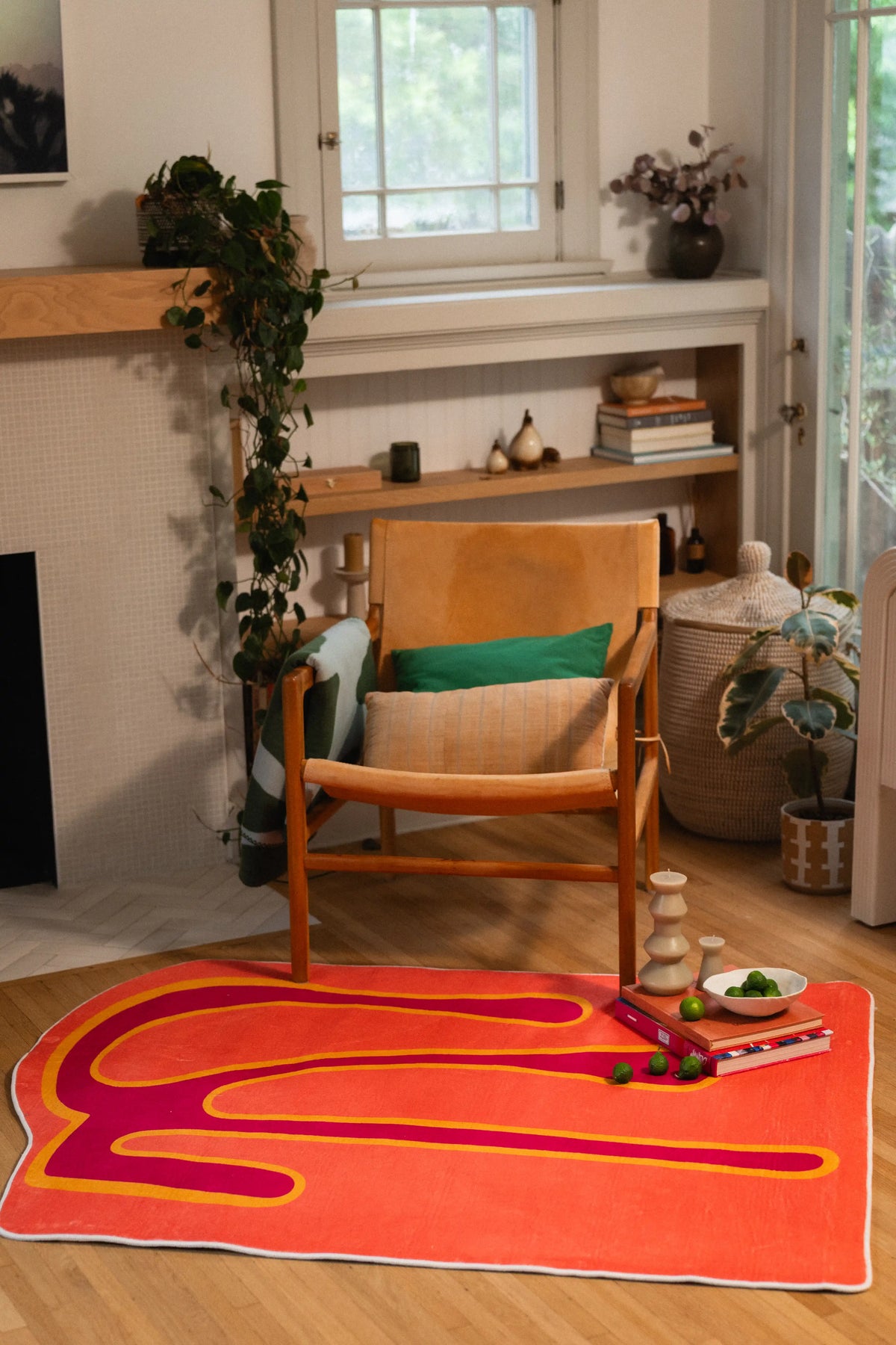 4' × 5' orange melting-pattern rug in front of a wooden armchair with a green cushion.