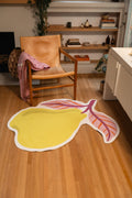 4' × 5' pear-shaped rug with yellow fruit and two pink leaves beside a wooden chair and white cabinet.