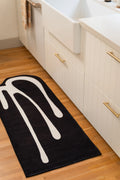 2' × 5' black kitchen runner with white melting lines beside a farmhouse sink and white cabinets.