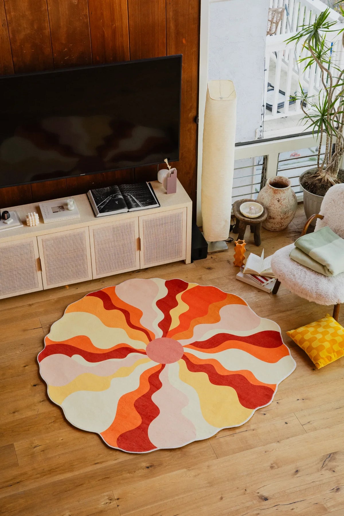 Unique Shaped Sundial Orange Rug by Maggie Stephenson in the living room, styled with a white armchair and floor lamp.