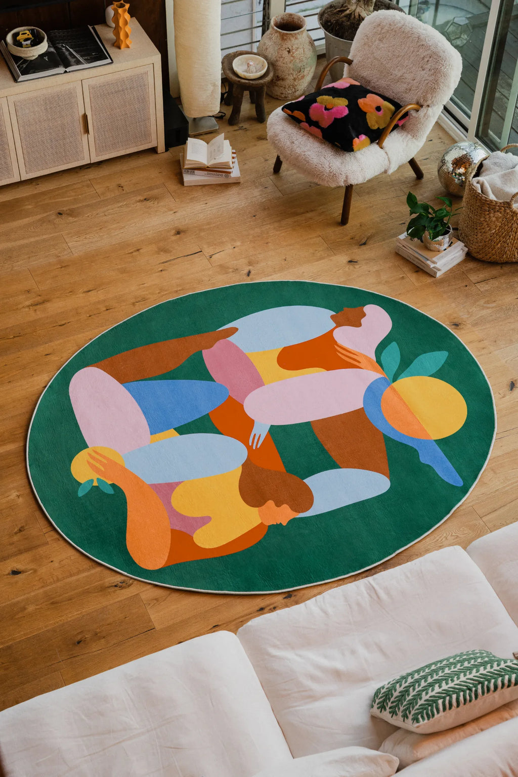 Fruitvine rug styled in a bright living room with boucle chair, floral cushion, and wood tones