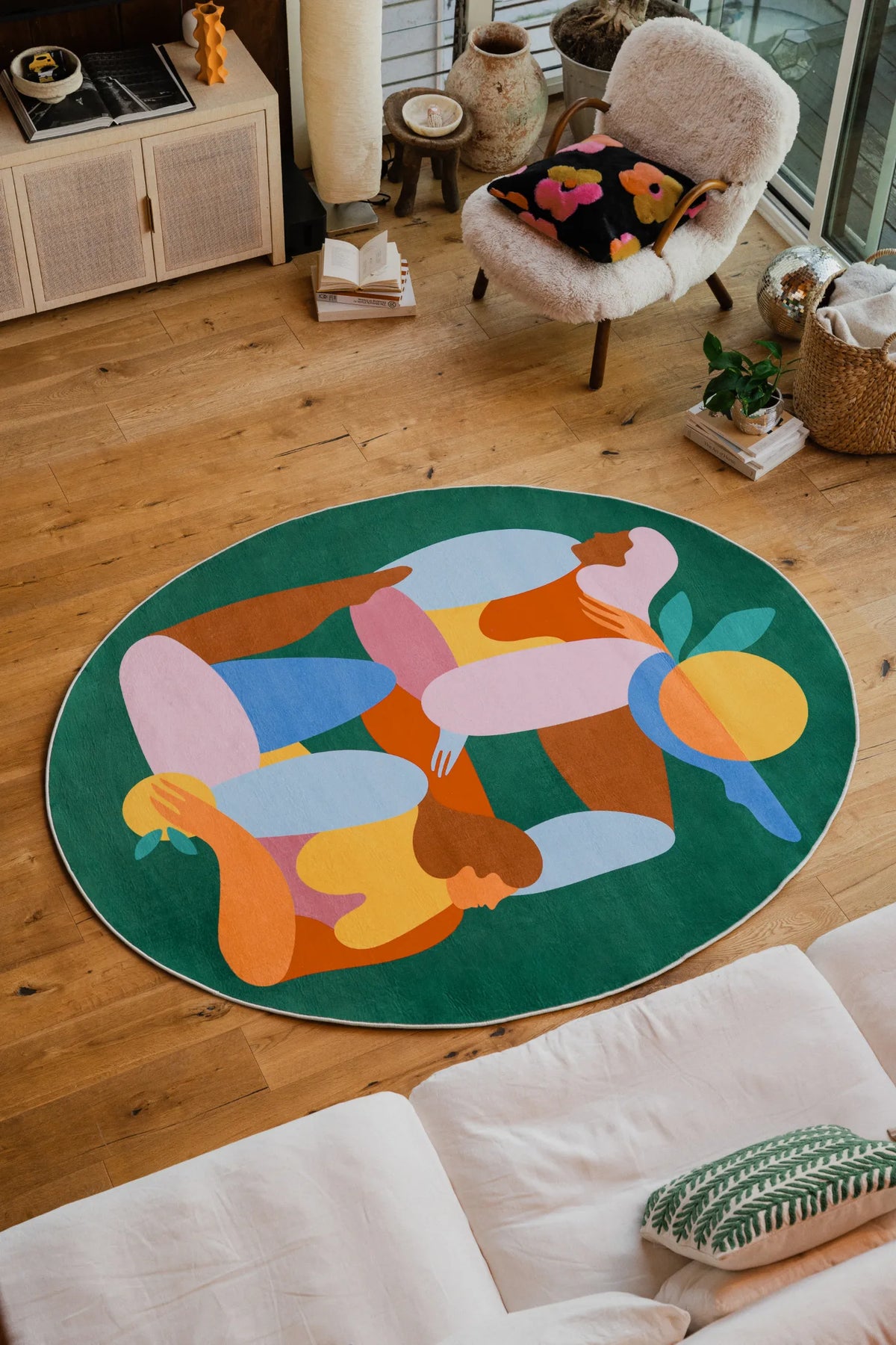 Fruitvine rug styled in a bright living room with boucle chair, floral cushion, and wood tones