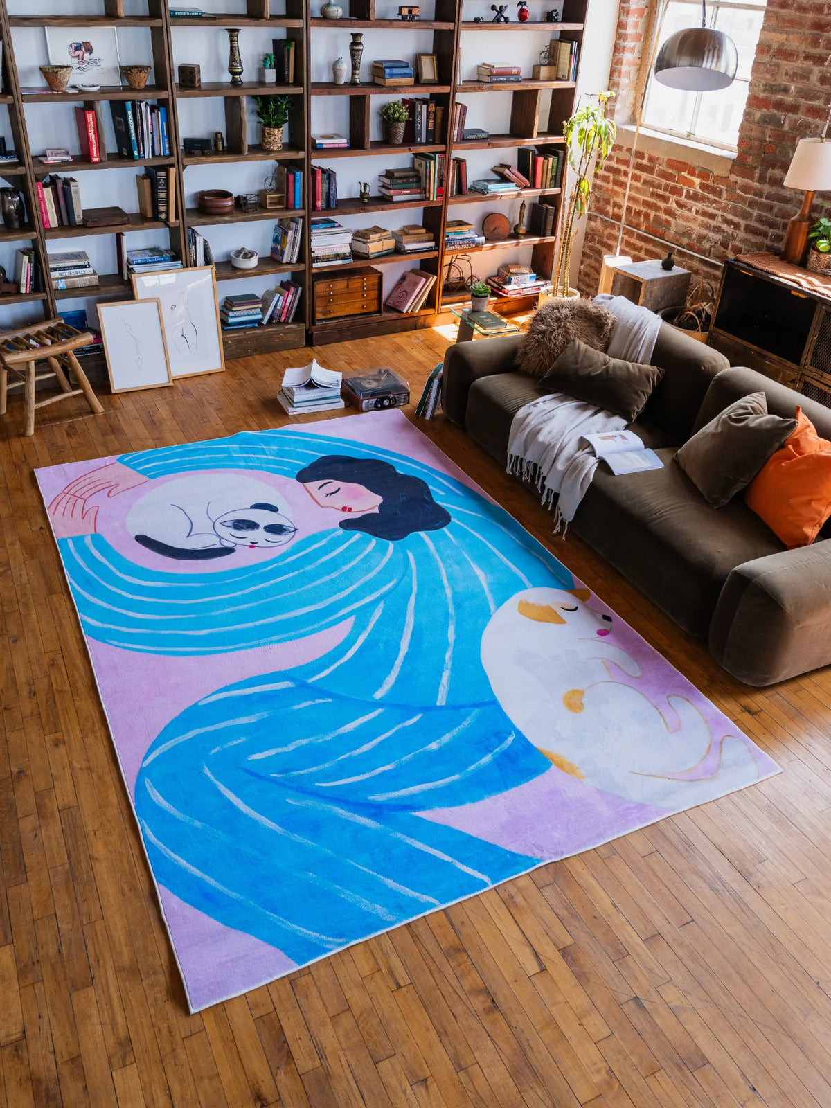 Funky Cat Lover Rug by Nimei in lilac and blue in 7'X10' feet, styled in a loft living room with bookshelves and a modern sofa.
