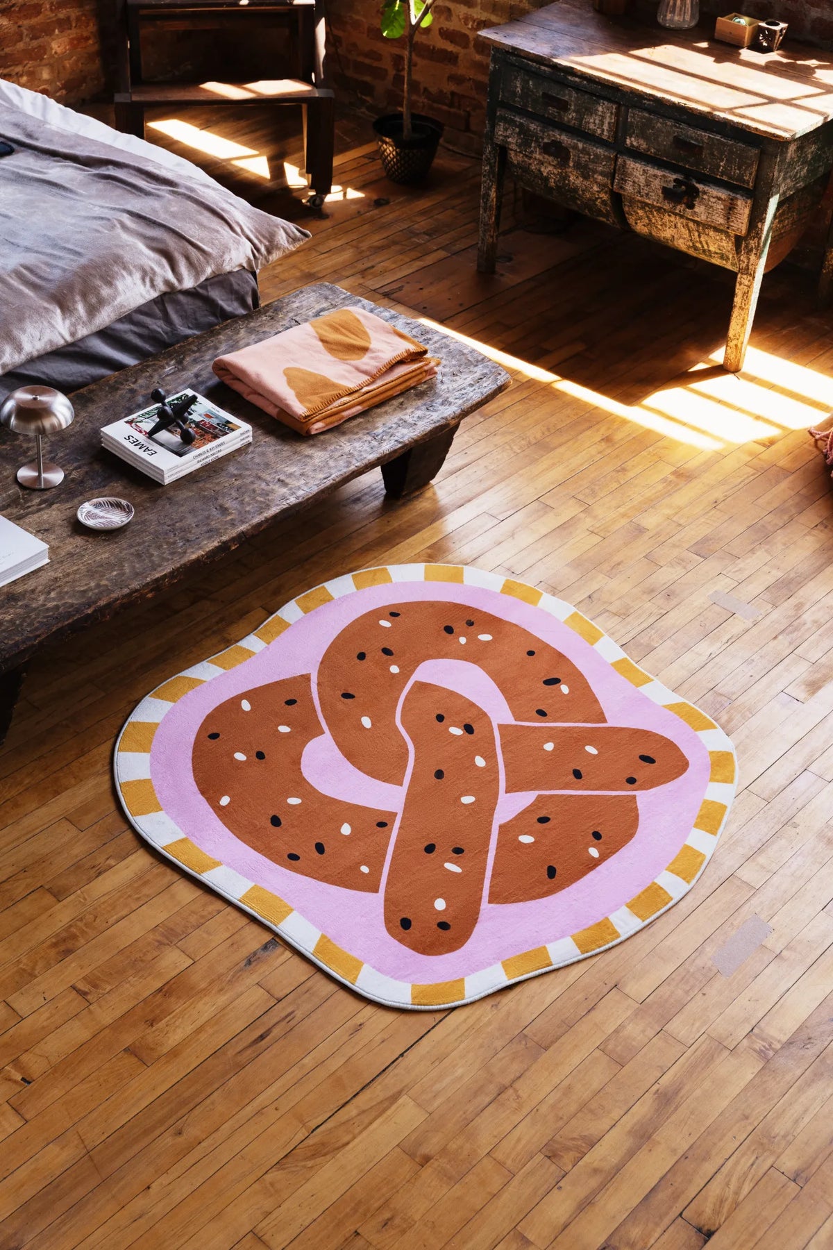 Pretzel-Shaped Cute Rug in brown placed on wood floor near sunlight and vintage wooden furniture in the bedroom