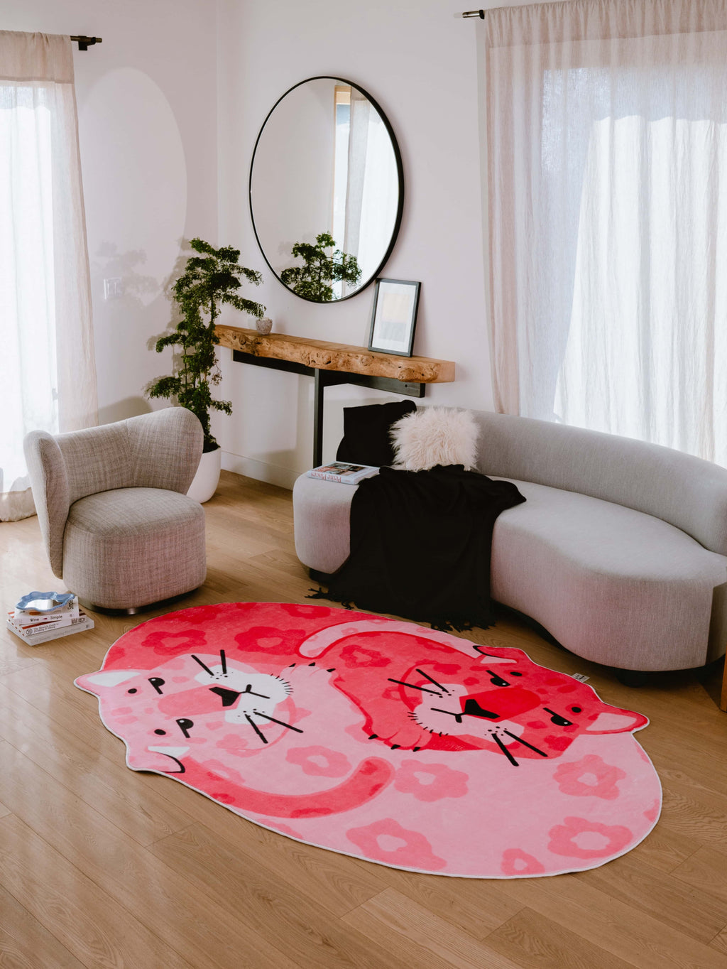 Soft curves of the pink panther rug anchor this bright, minimalist living room setup.
