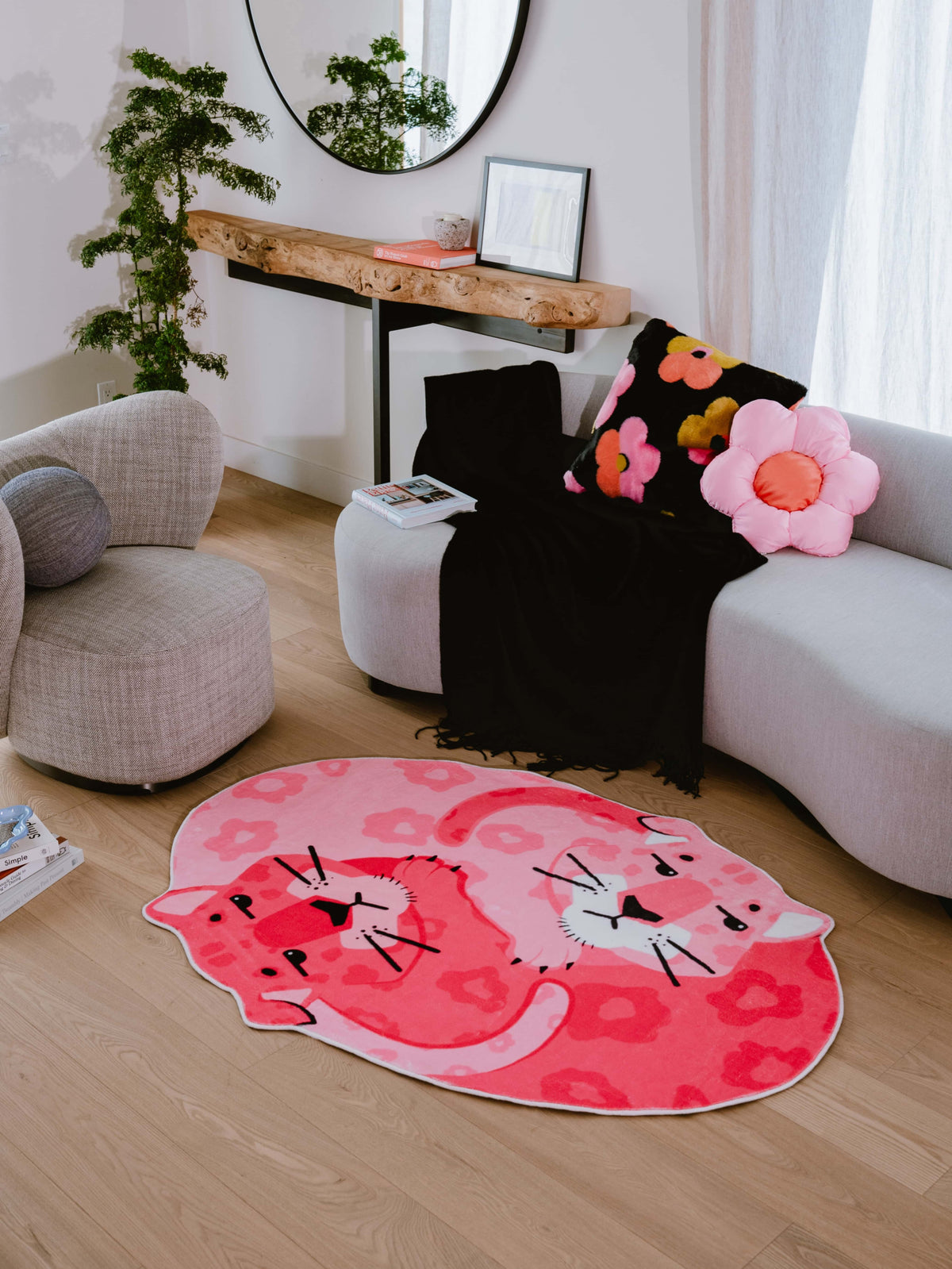 Pink panther rug by the couch in a sunlit living room, styled with floral cushions and boucle chairs for a playful cozy vibe.