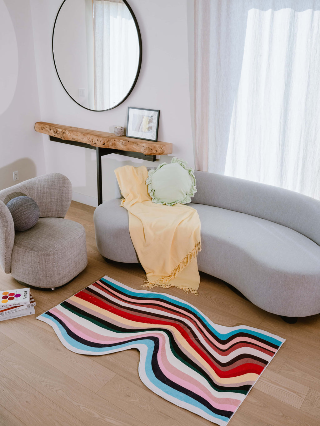 Irregular shaped multicolor contour runner rug in bright living room, styled with curved sofa and rustic wood console table.