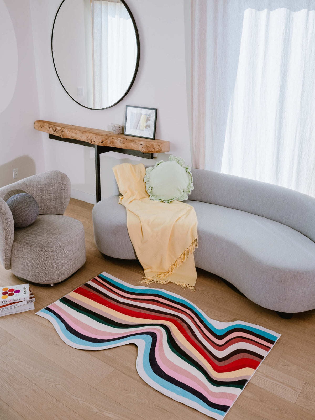 Irregular shaped multicolor contour runner rug in bright living room, styled with curved sofa and rustic wood console table.