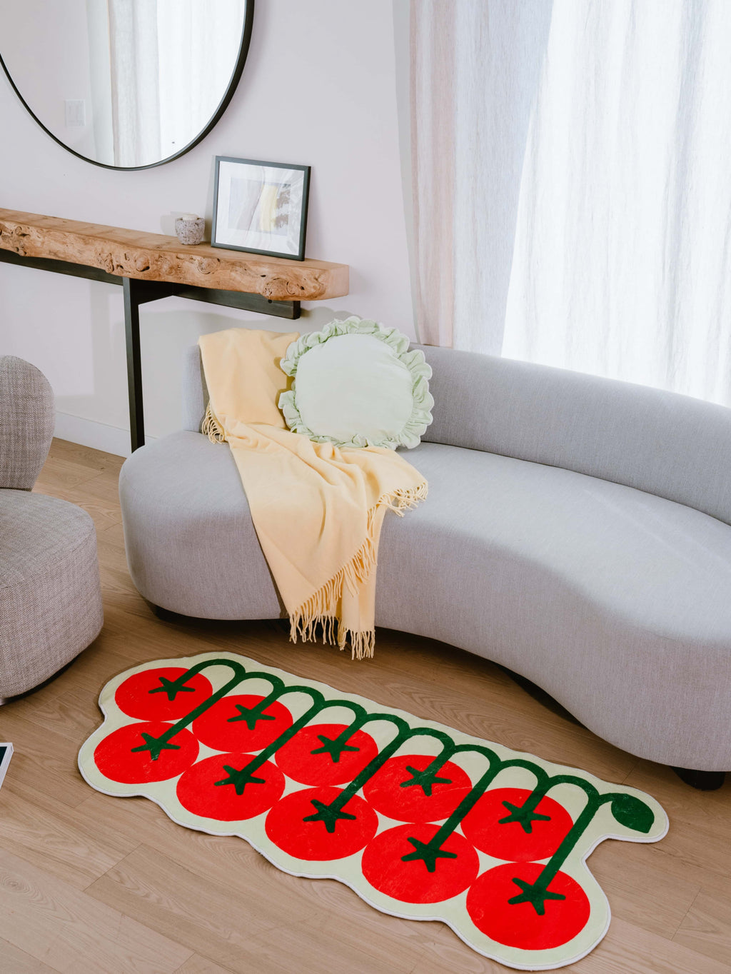 Irregular Tomato Runner Rug by Johann Banta placed in a sunlit living room, paired with a curved sofa.