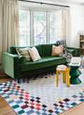 Living room with green sofa styled on the Pixel Multicolor Checkered Rug, paired with yellow and green side tables.