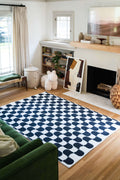 Black and White Wavy Rug styled in a cozy living room with a fireplace, green couch, and bookshelf.