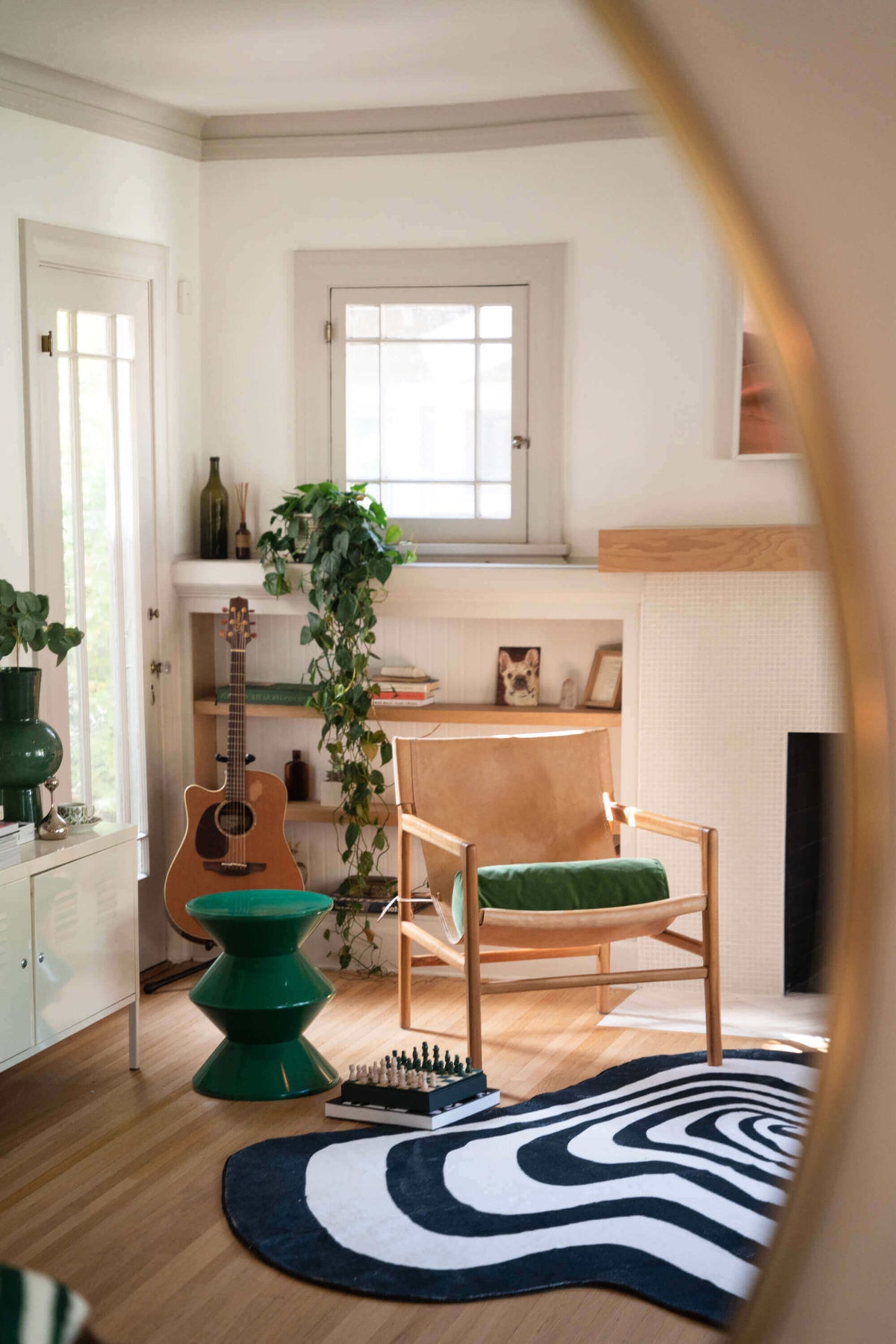 Vertigo rug partially visible beneath a lounge chair and green side table in a cozy corner.