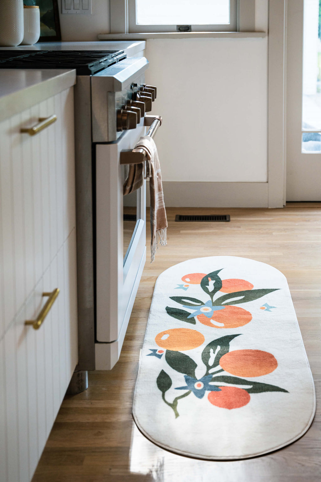 Orange Pattern Mat by the kitchen stove in a bright cooking space.
