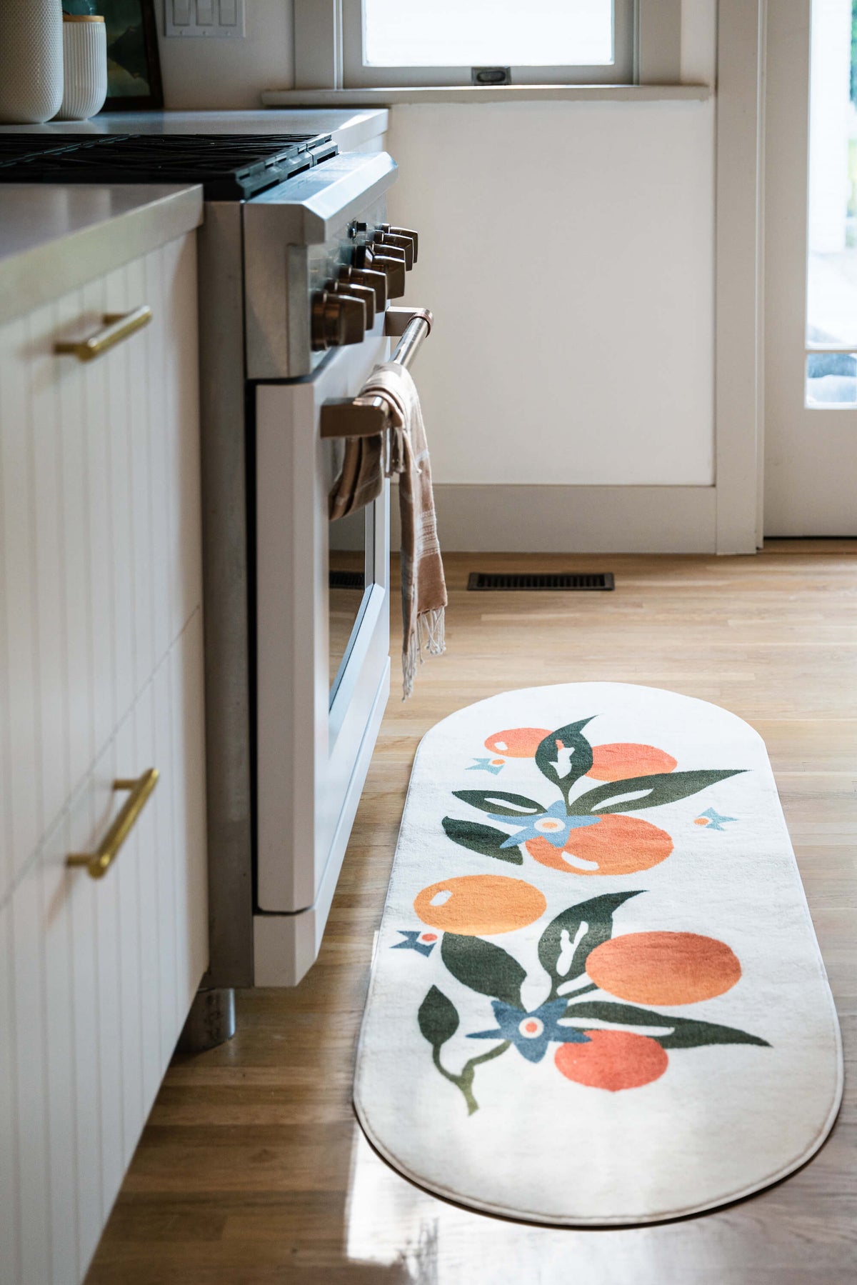 Orange Pattern Mat by the kitchen stove in a bright cooking space.