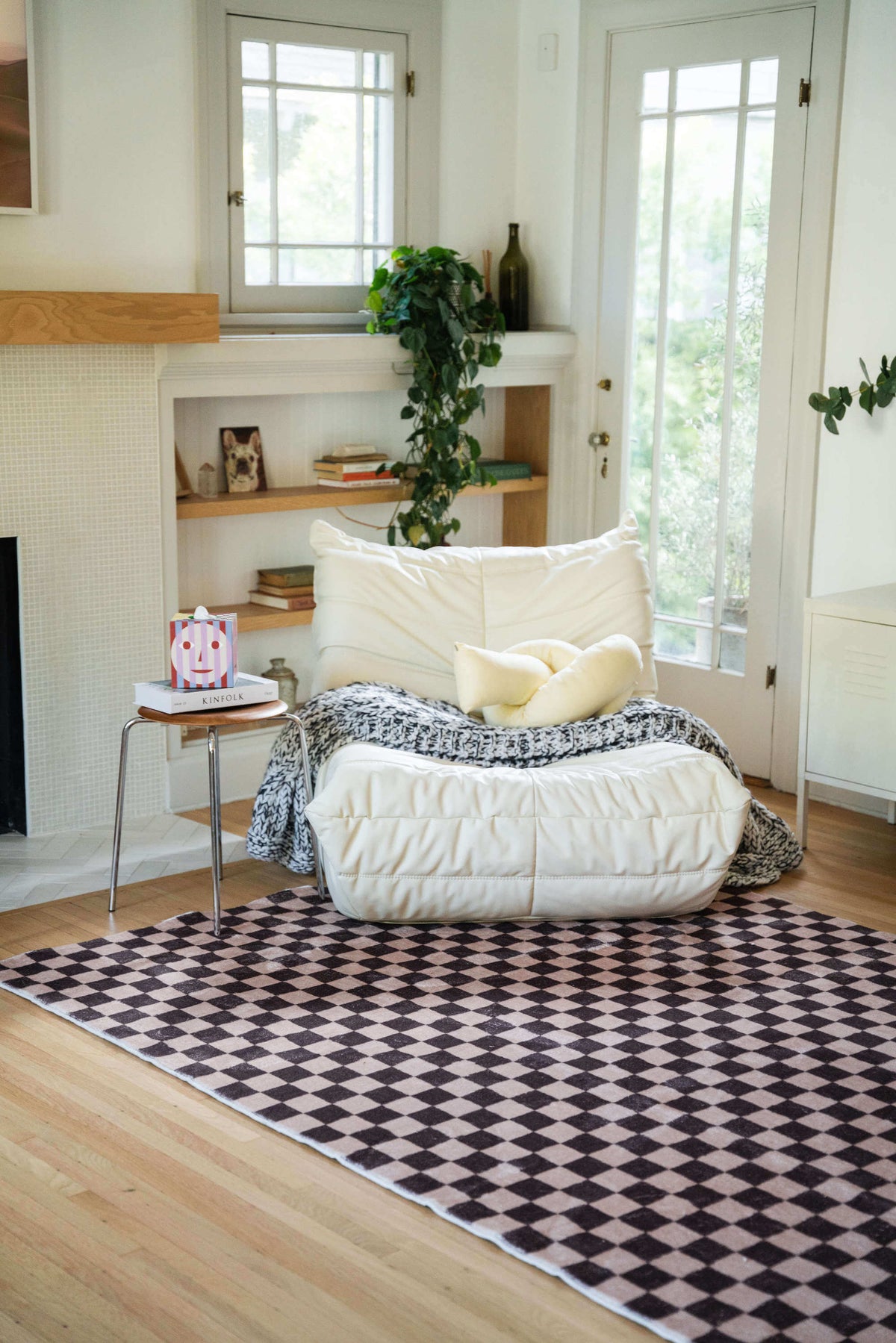 Chocolate Brown Checkered Rug styled in a cozy reading nook with a white lounge chair and natural wood accents.