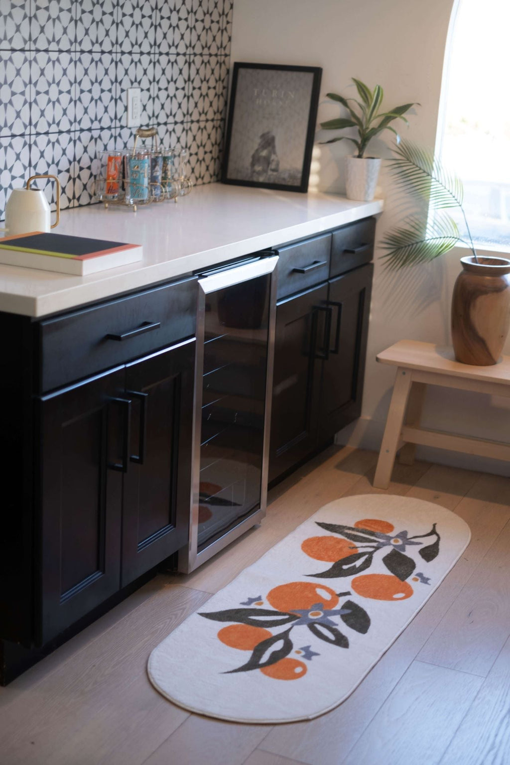 Orange pattern mat placed along dark cabinetry in a modern kitchen.