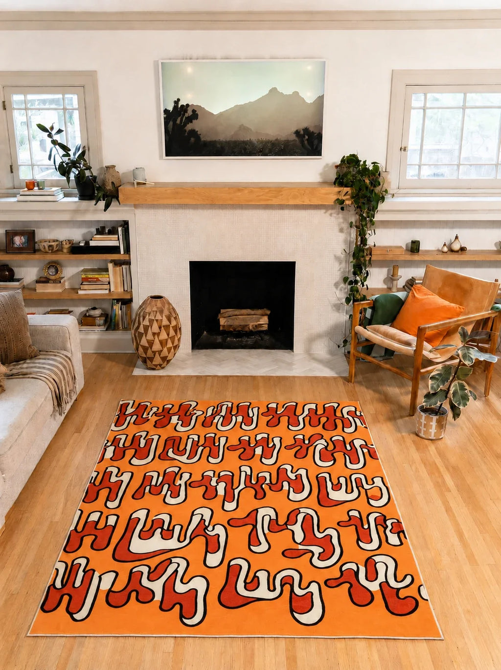 5' × 7' orange Squiggle Abstract Rug by Ariana Berman centered on a wood floor in front of a fireplace.