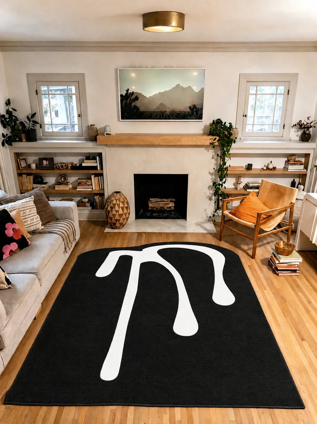 7' × 9' Black and White Melting Abstract Art Rug by Ariana Berman between a gray sofa and wooden armchair in a living room.