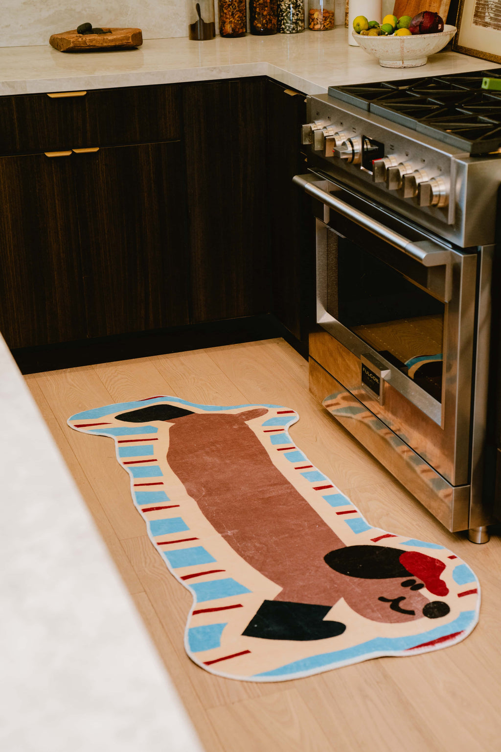 Charming brown dog runner rug on kitchen floor, placed by the stove and cabinetry with soft ambient lighting.