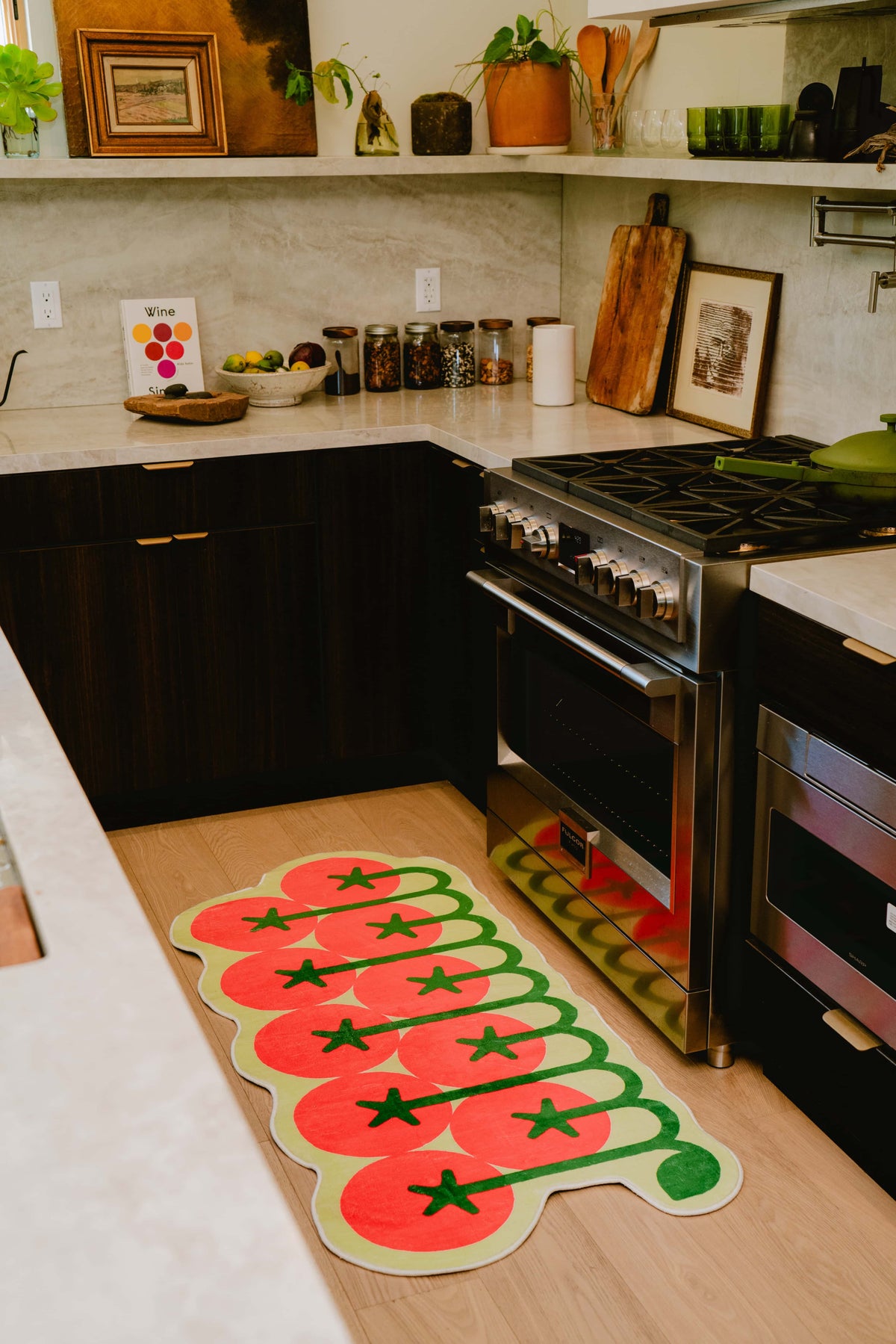 Tomato rug stretching by the stove, complementing the wooden floor and contemporary dark cabinetry.