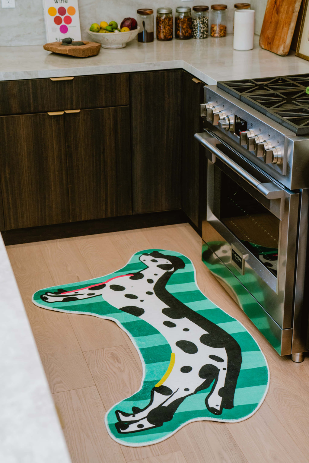 Green dog runner rug positioned in a modern kitchen next to oven and brown lower cabinets.