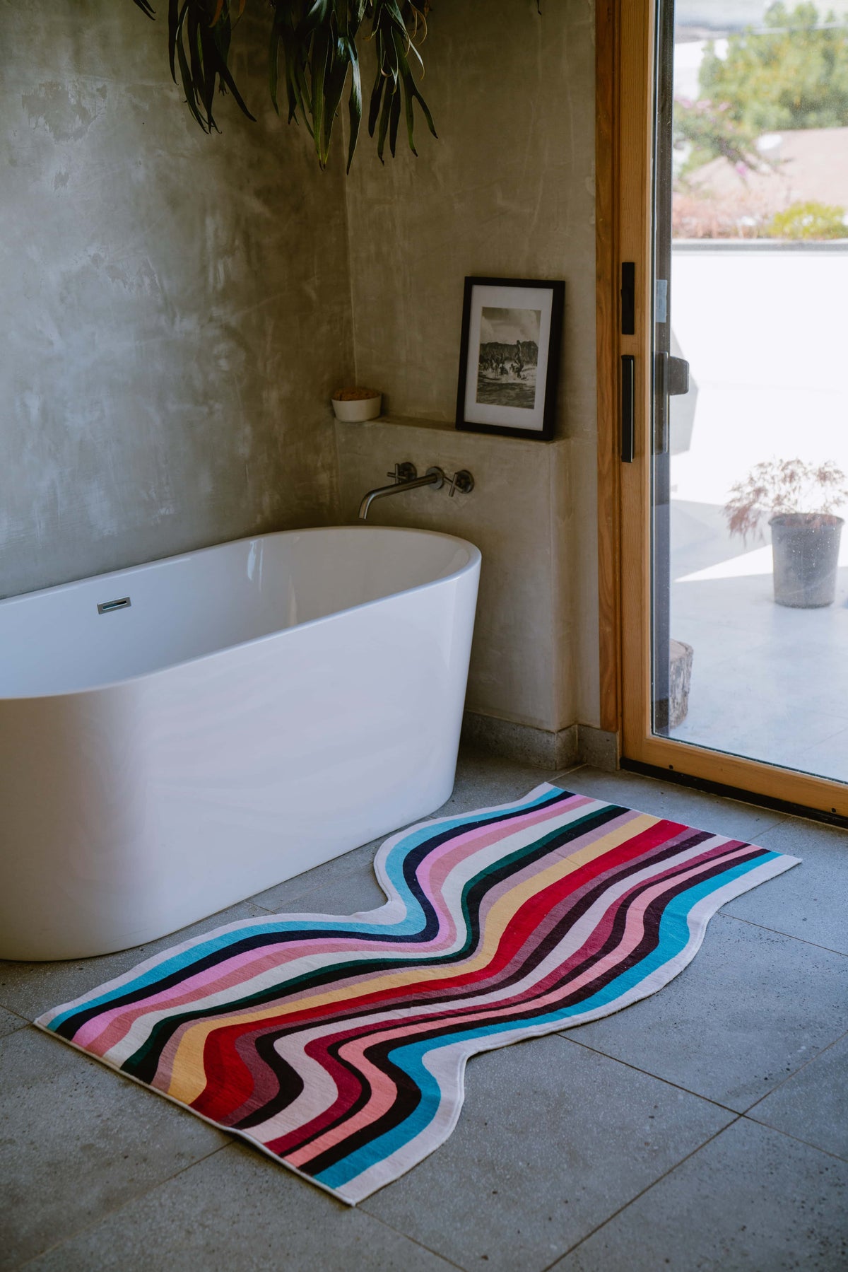 Irregular Shaped Multicolor Contour Runner Rug by bathtub in a bright, natural-lit bathroom with concrete walls.