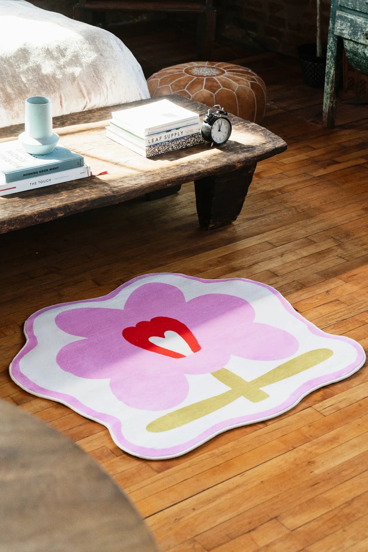 Flower Rug by Anne Julie in pink version set under rustic low table with morning light across wood floor