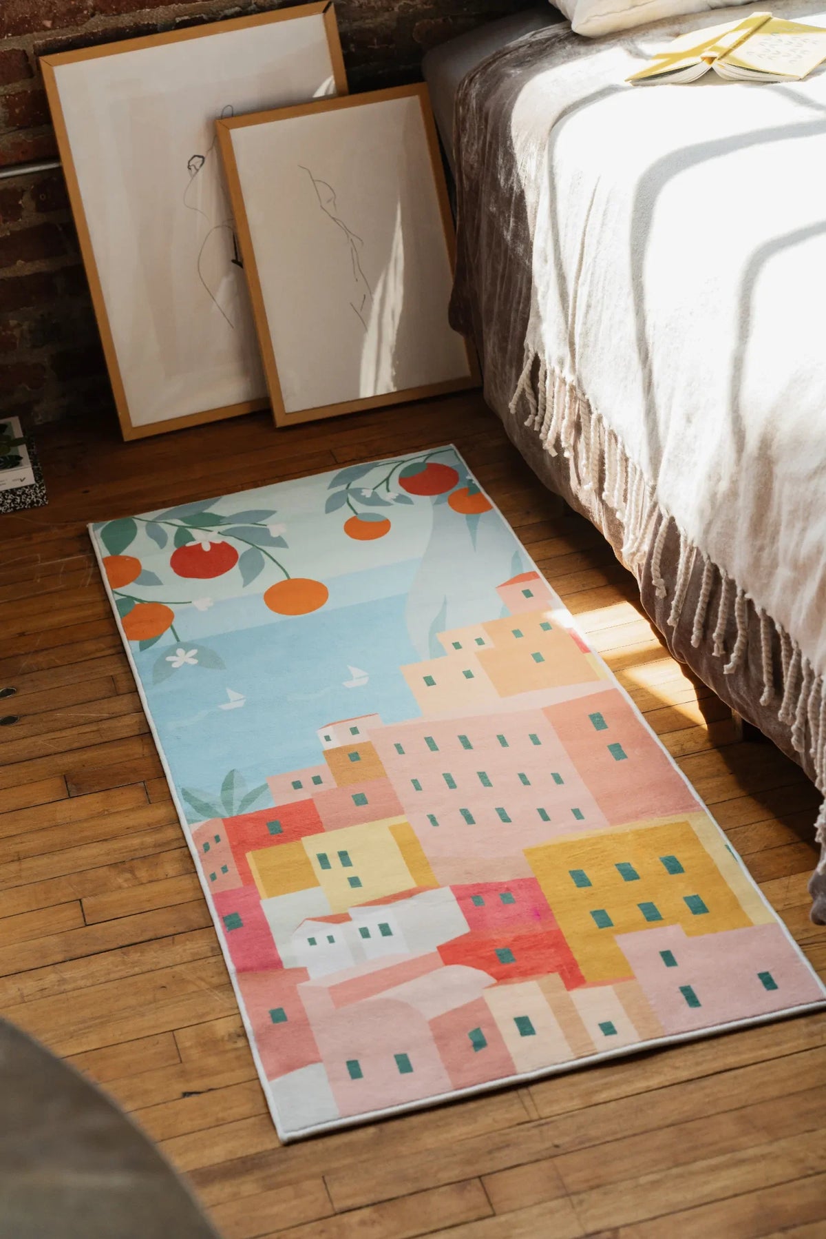 A playful Italian village runner adding color on wooden floor next to framed sketches