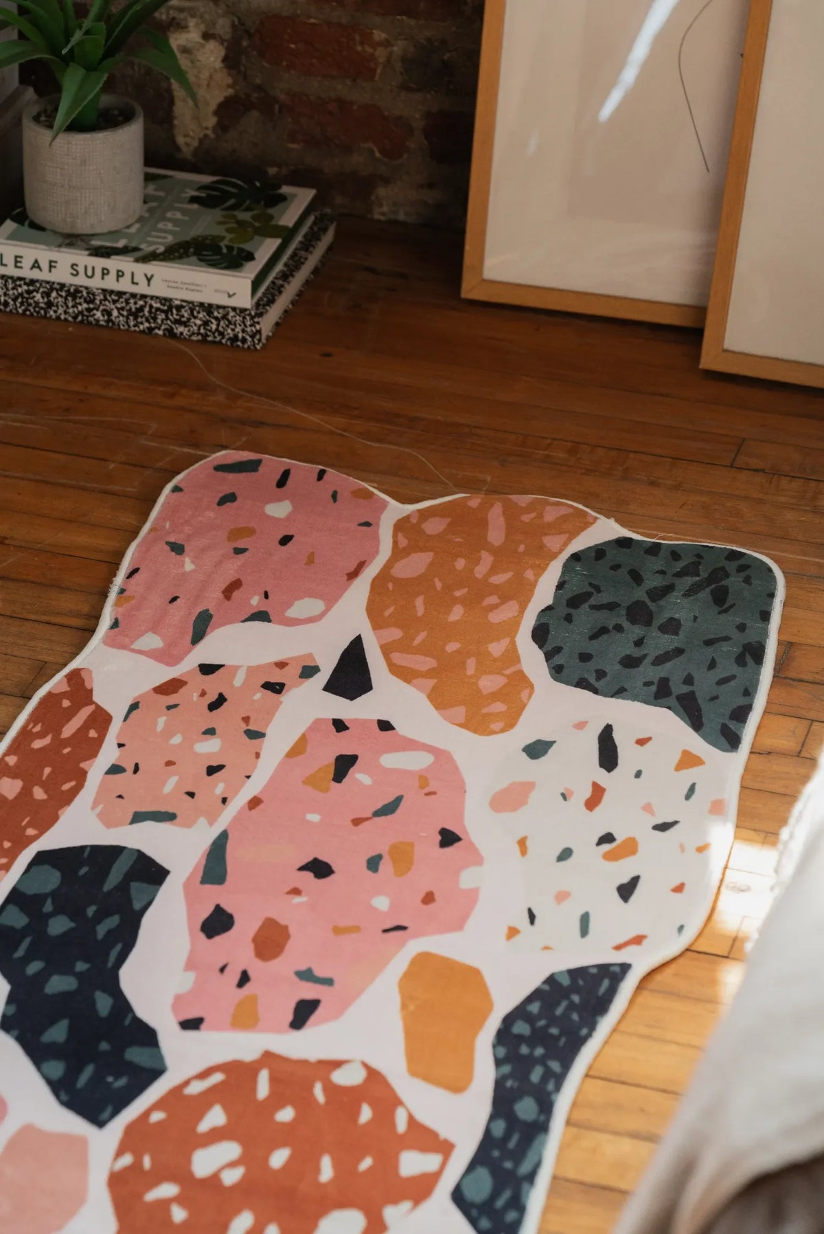 Close view of a mosaic abstract runner rug laid on wood floor, highlighting its flowing colorful design.