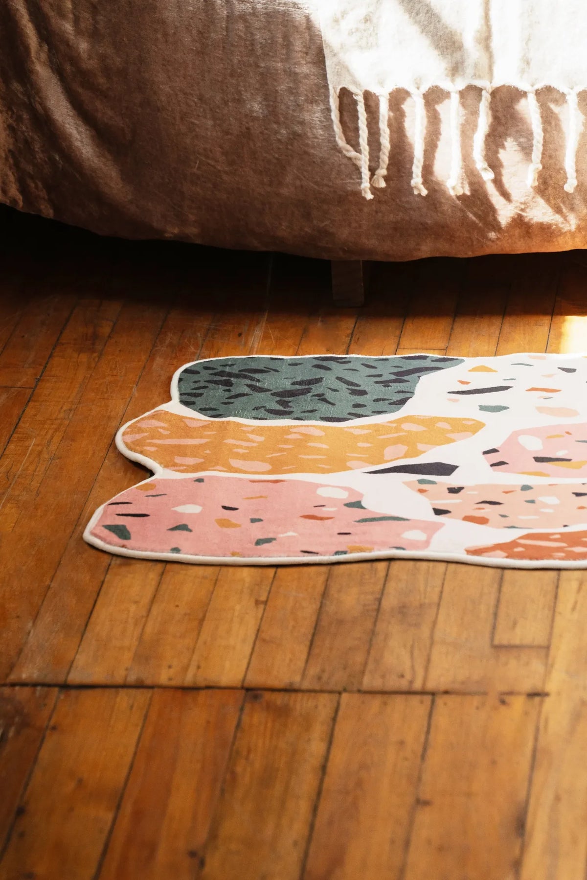 A mosaic abstract runner rug set on wood floor beside the bed, showcasing layered mosaic details.