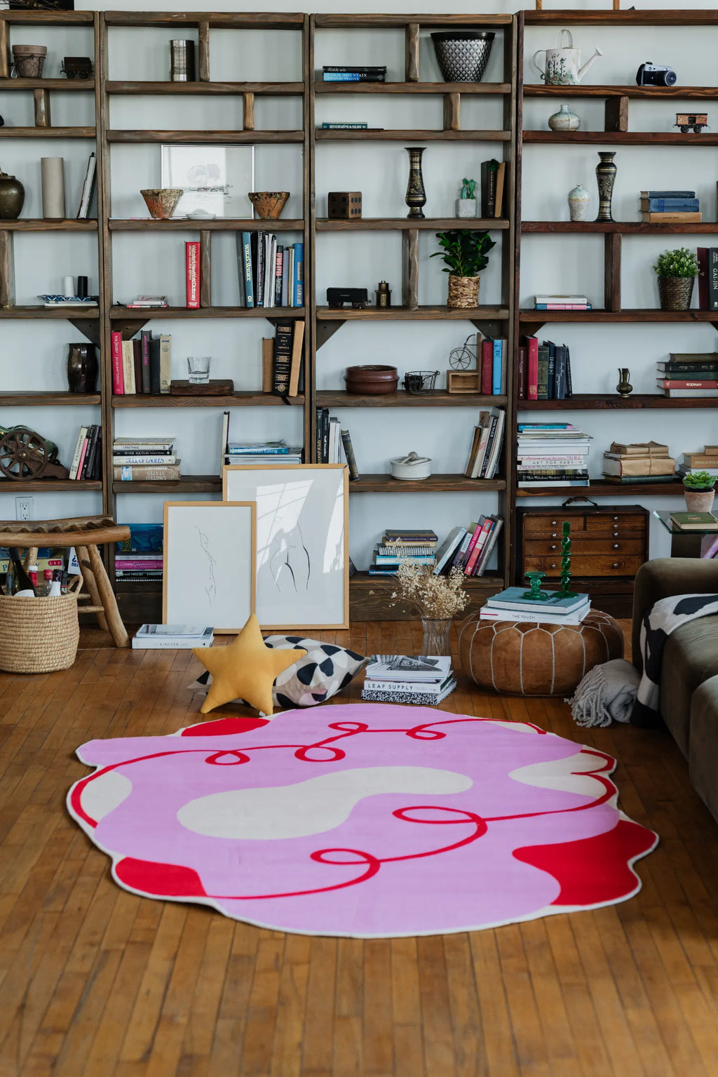 Pink funky area rug in 5'X7' size with red curvy patterns, styled in a cozy living room setup.