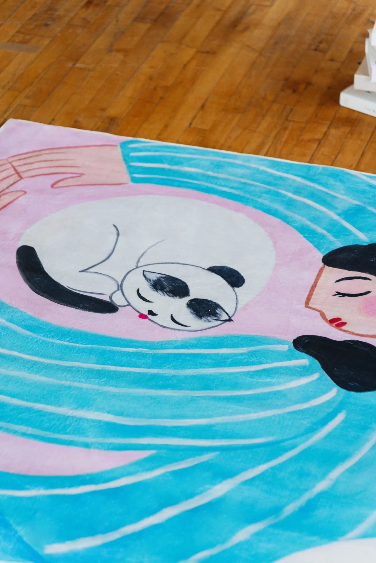 Close-up of the Cat Lover Rug highlighting the playful cat illustration and gentle blue waves, styled against warm wooden flooring.