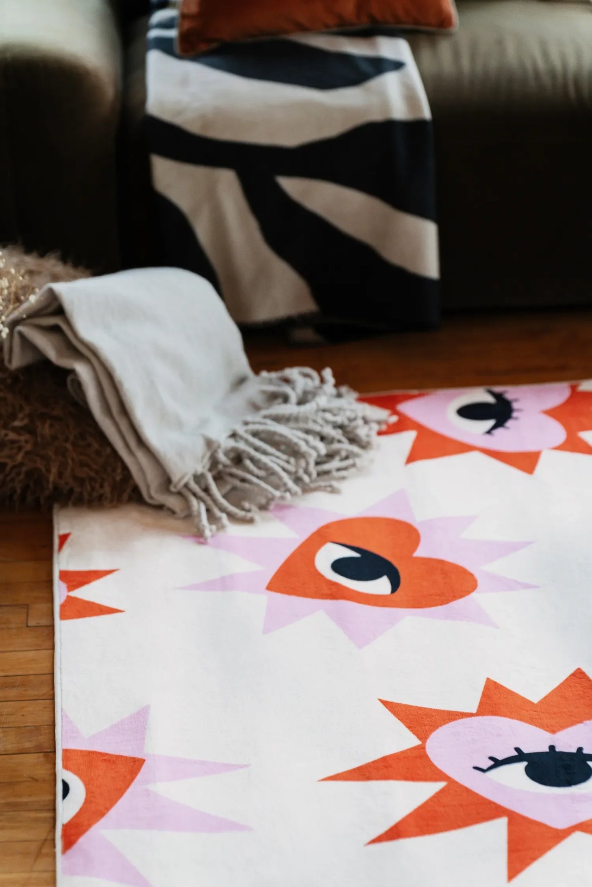 Heart Eye Pattern Rug placed beside sofa with soft blanket and patterned throw adding playful accent to the corner