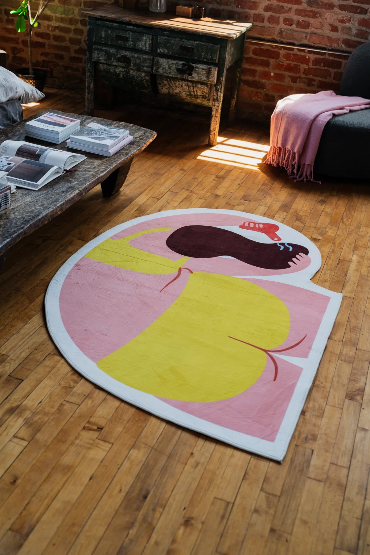 Funky body art rug in playful tones, captured from a diagonal loft corner with sunlight on wooden floor.