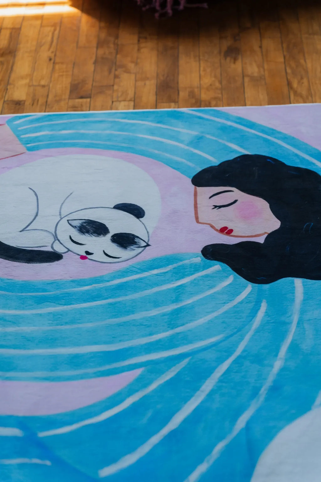 Funky Cat Lover Rug by Nimei featuring dreamy woman and cat design, set on warm wood floor under soft natural light.