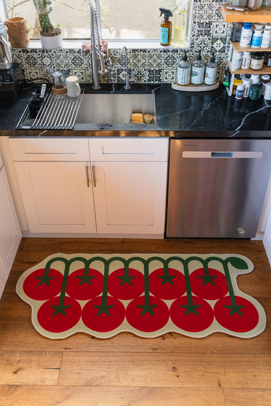 Tomato runner rug by sink in natural light, adding a fun touch to this cozy kitchen corner.