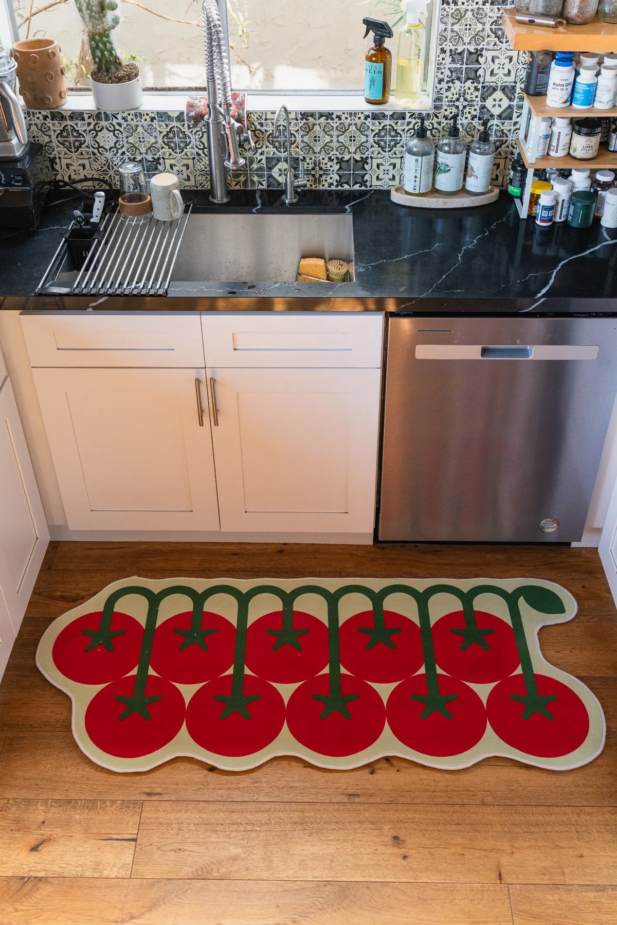 Tomato runner rug by sink in natural light, adding a fun touch to this cozy kitchen corner.